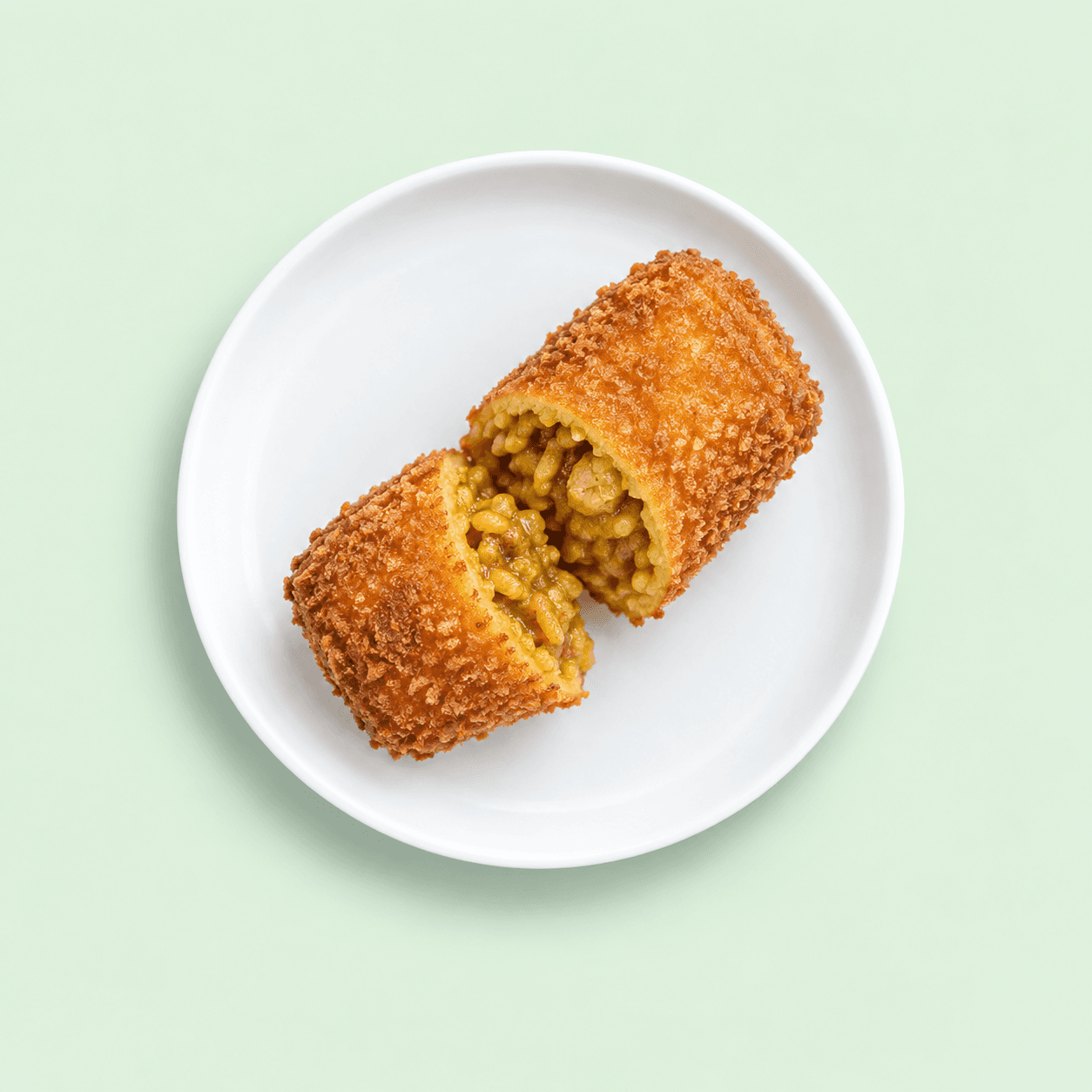 Golden crumbed curry and rice roll cut open to show its filling
