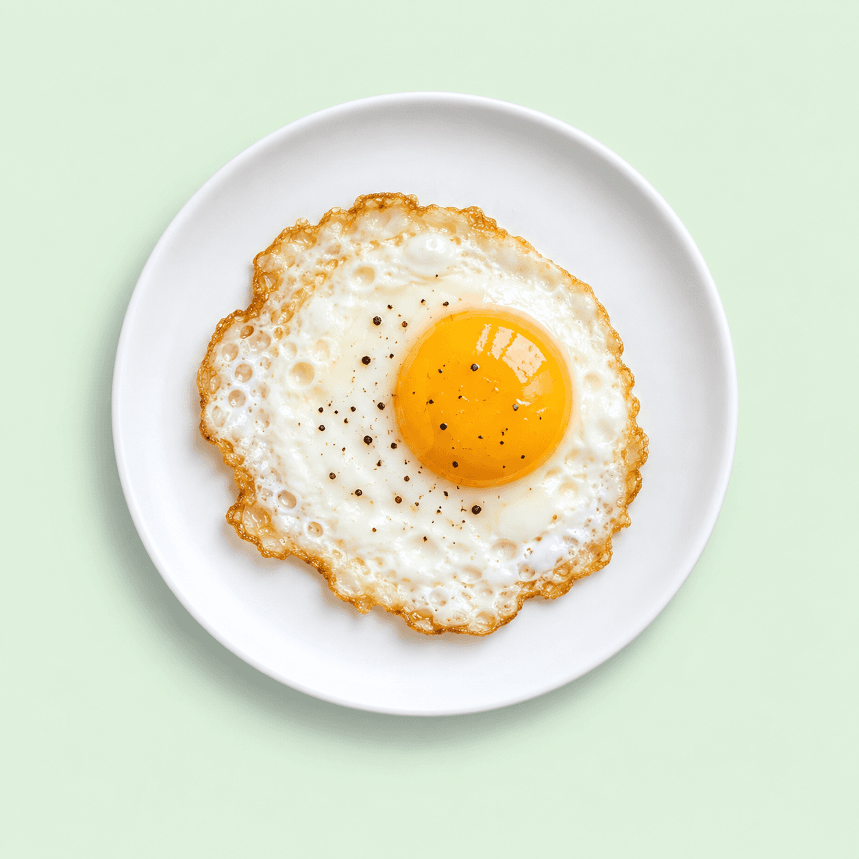 Fried egg with a golden yolk on a white plate