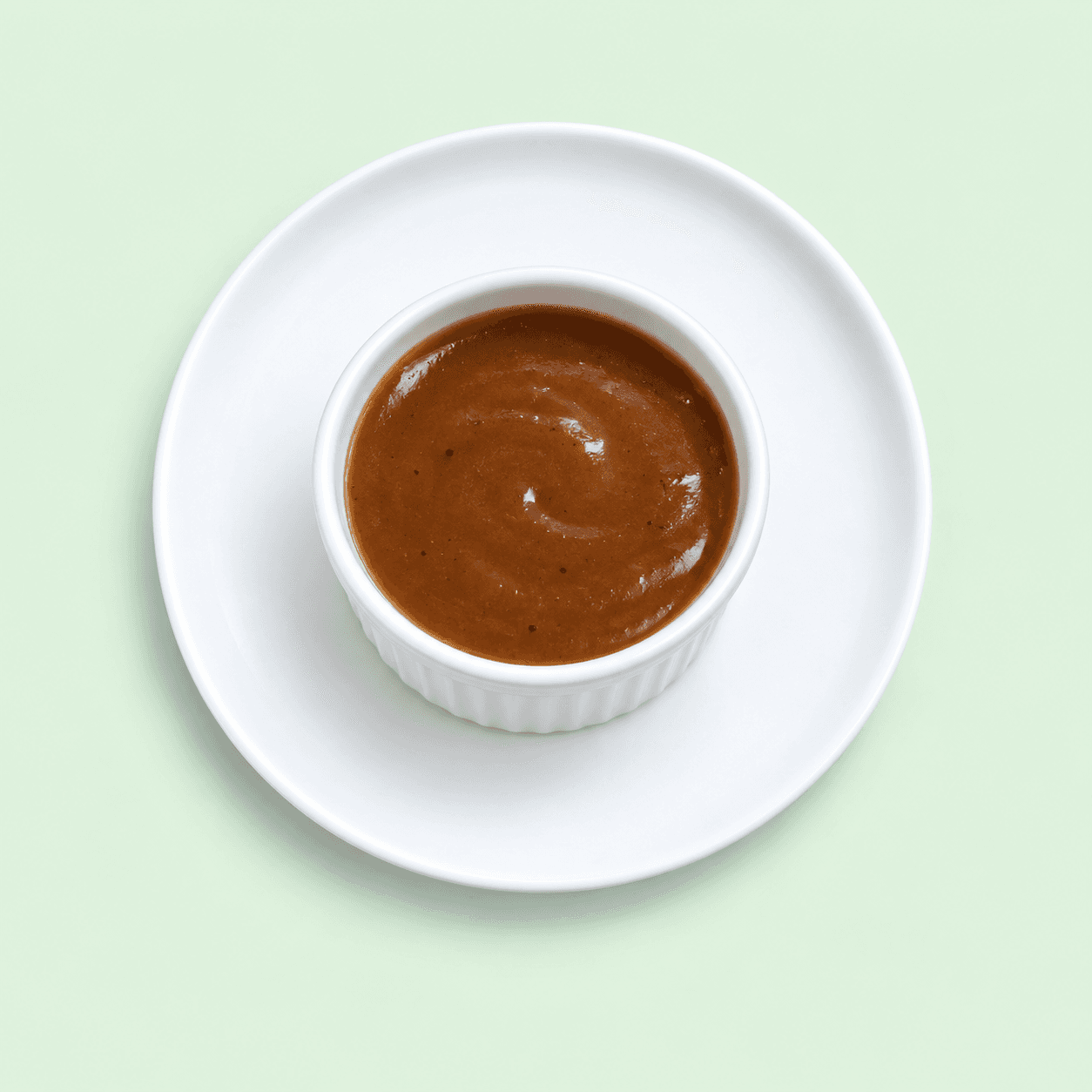 Rich brown gravy in a small white ramekin