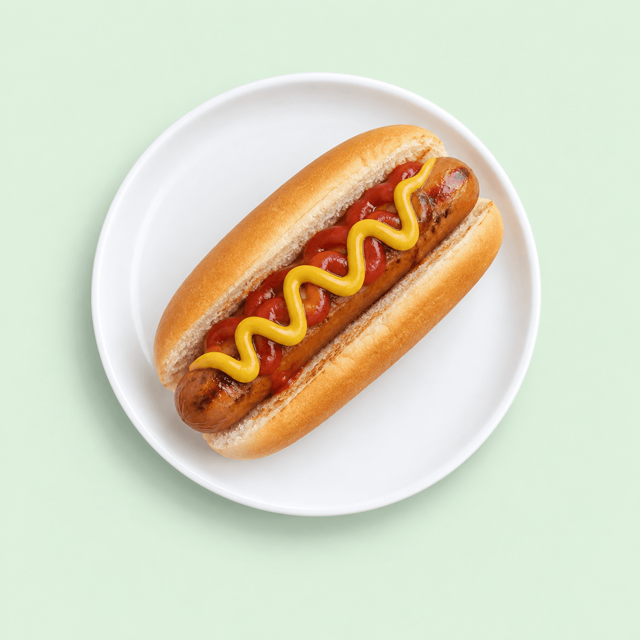 Hot dog in a soft bun topped with mustard