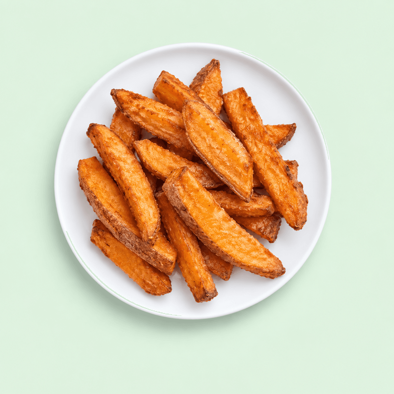 Crisp orange kumara chips on a white plate